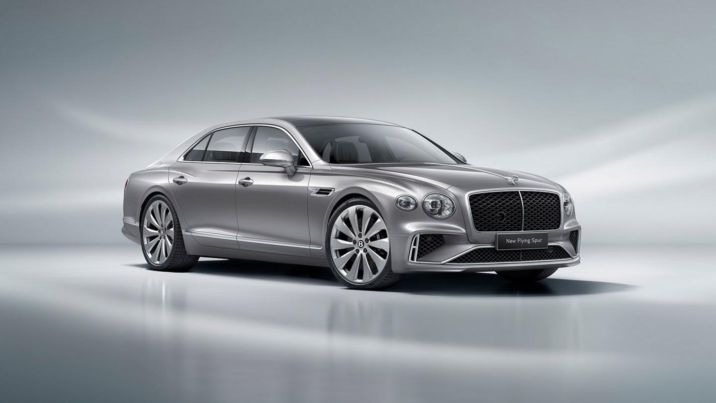 Front three quarter of the new hybrid Flying Spur in the Moonbeam exterior colour and featuring directional 22' wheels