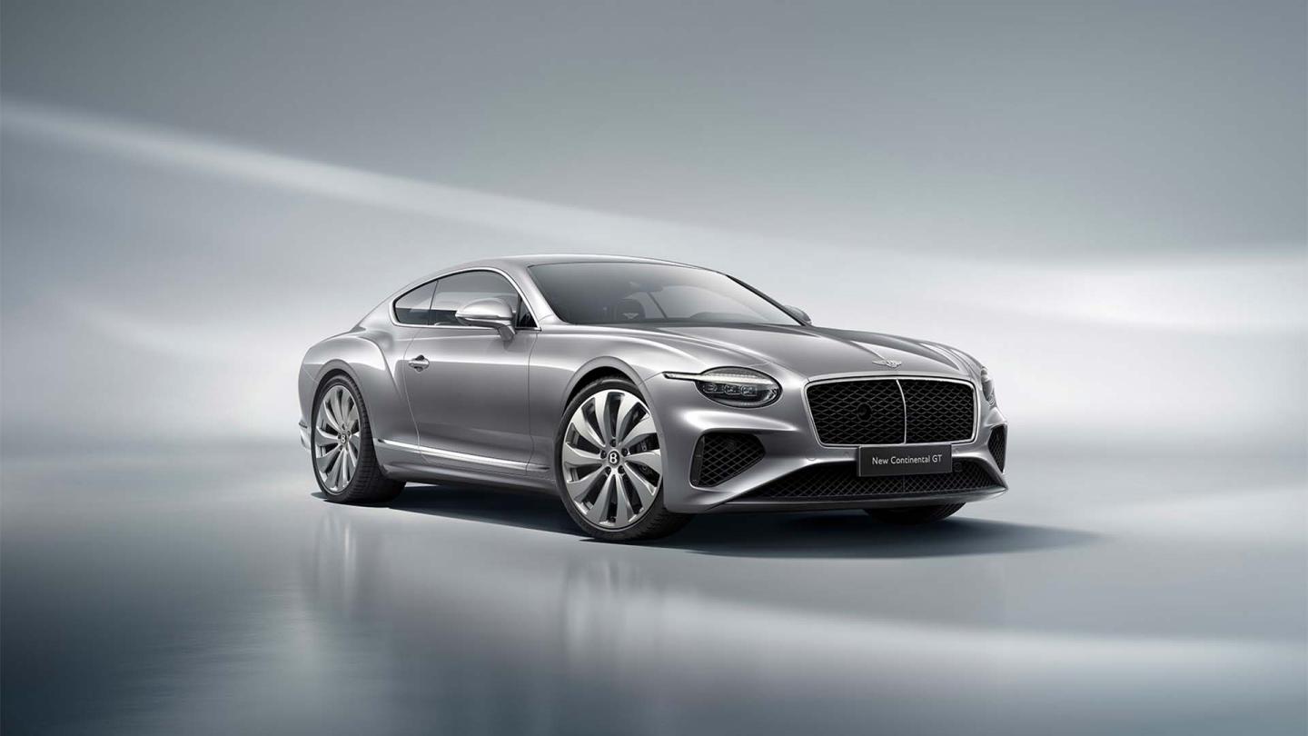 Front three quarter of the new hybrid Bentley Continental GT in a Moonbeam exterior featuring 22" directional wheels