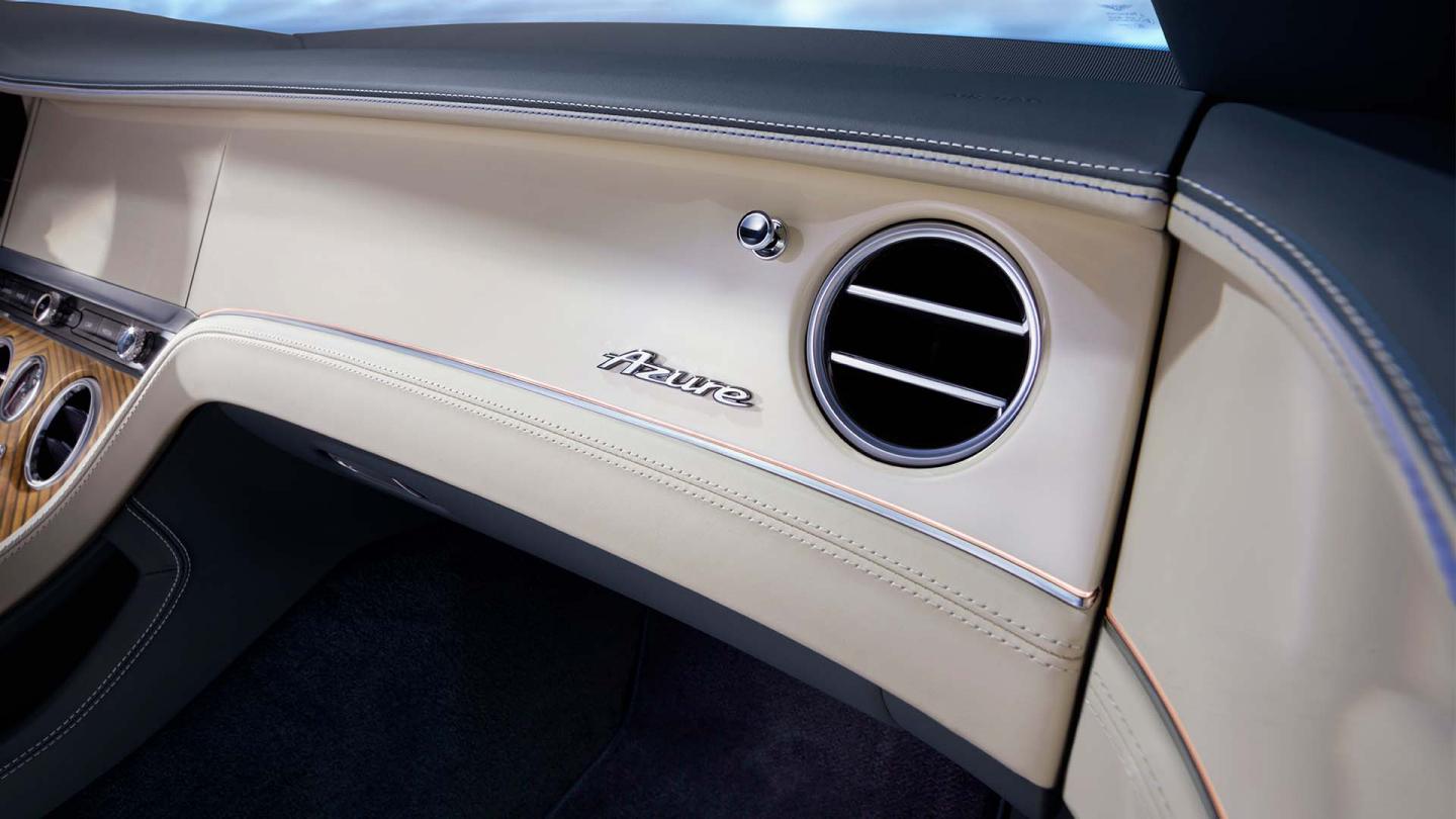 Rear side angled view of Bentley Continental GTC Azure with roof down in Topaz Blue colour featuring Bentley boot badge and quad tailpipes.
